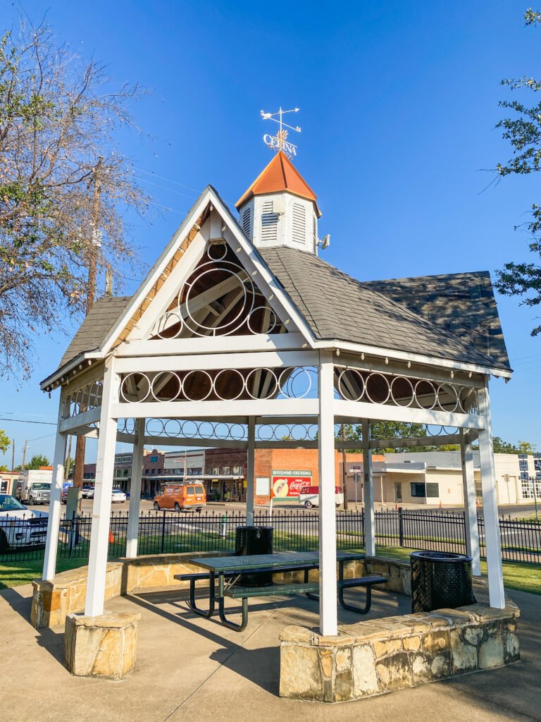 A white gazebo in a park at the edge of downtown Celina, Texas