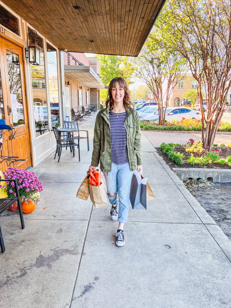 A woman walking the historic Celina square with shopping bags on day trips from Dallas