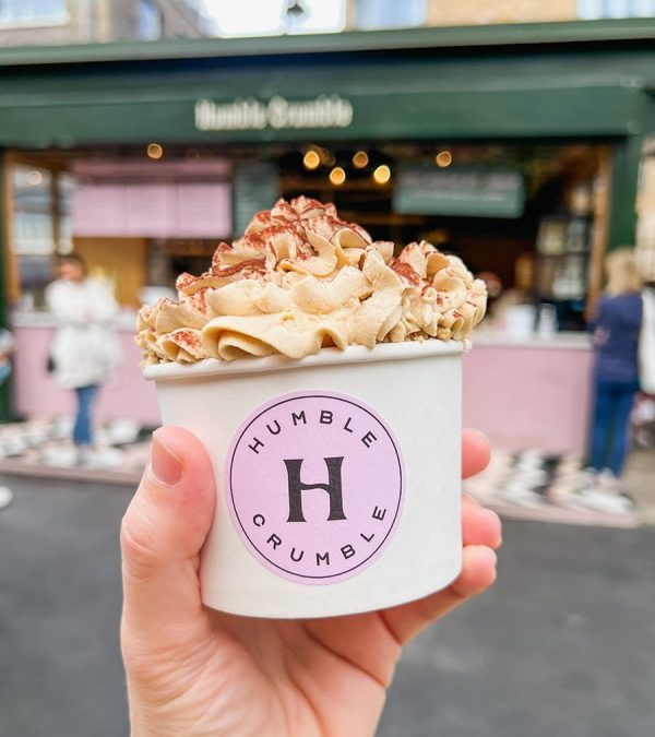 A hand holding a cup of Tiramisu Crumble from Humble Crumble at Borough Market in London